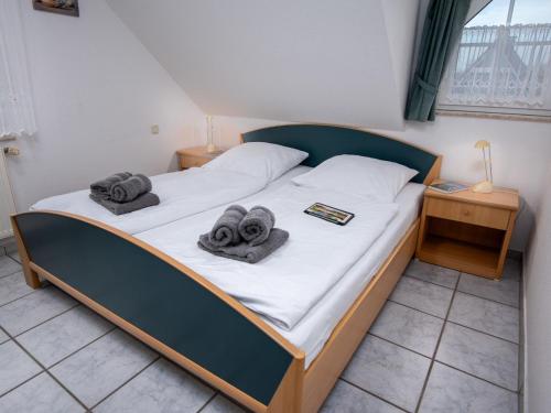 een slaapkamer met een bed met handdoeken erop bij Apartment Möwe by Interhome in Norddeich