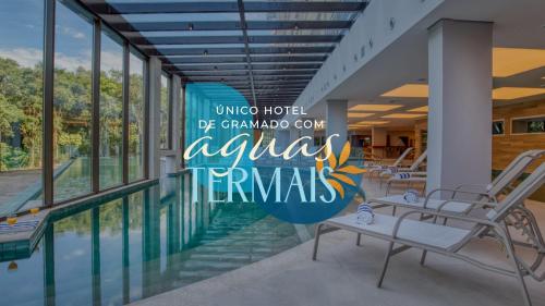 Wyndham Gramado Termas Resort & Spa في غرامادو: لوبي فيه مسبح و لوحة مكتوب عليها فندق العم يكون جد لنا