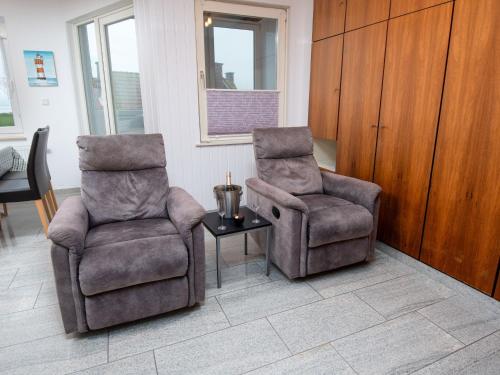 2 Stühle und ein Tisch im Wohnzimmer in der Unterkunft Apartment Seerose by Interhome in Norddeich