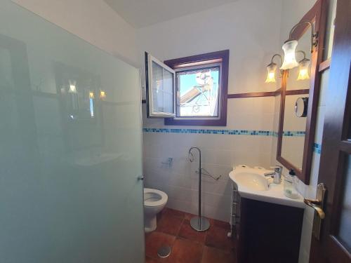 a bathroom with a toilet and a sink and a mirror at Casa Bayon in El Paso