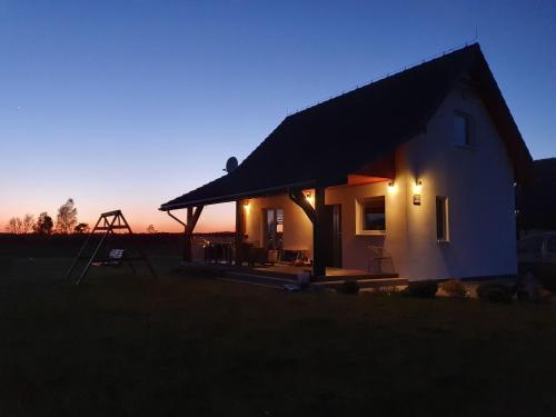 a small house with a sunset in the background at Holiday Home Modrzewiowy Zakątek by Interhome in Smołdziński Las