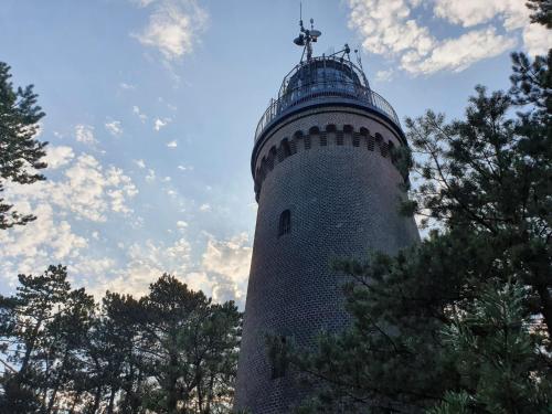 a lighthouse with a cross on top of it at Holiday Home Modrzewiowy Zakątek by Interhome in Smołdziński Las