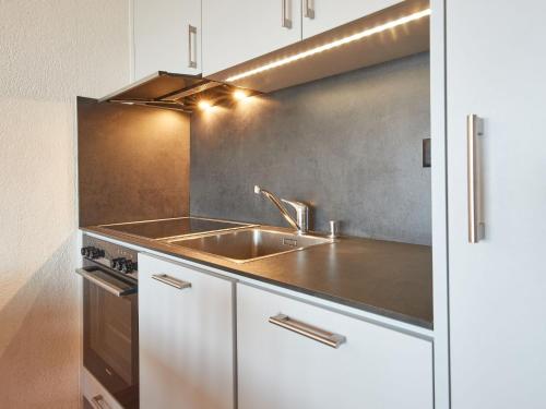 a kitchen with a sink and a stove at Apartment Flache 401 by Interhome in Les Collons