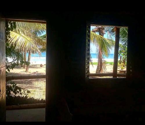 a window view of a beach with palm trees at Suit frente al Mar in Montañita