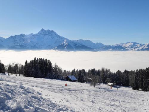 a snow covered slope with mountains in the background at Chalet Chalet Lorila by Interhome in Villars-sur-Ollon