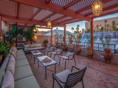 a patio with couches and tables and chairs at Riad Maialou & SPA in Marrakech