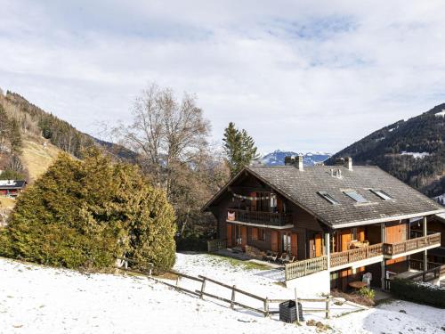 a house in the snow with mountains in the background at Apartment Brocard by Interhome in Val dʼIlliez
