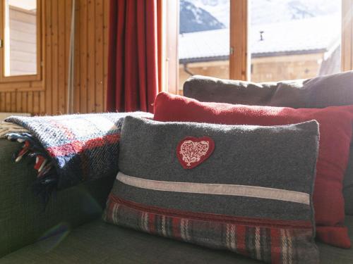 a group of pillows on a couch in front of a window at Apartment Brocard by Interhome in Val dʼIlliez