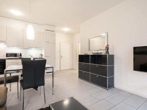 een keuken en een woonkamer met een eettafel en een televisie bij Apartment Victoria View by Interhome in Interlaken