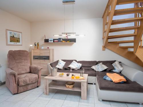 ein Wohnzimmer mit einem Sofa, einem Stuhl und einem Tisch in der Unterkunft Holiday Home Aquantis by Interhome in Norddeich