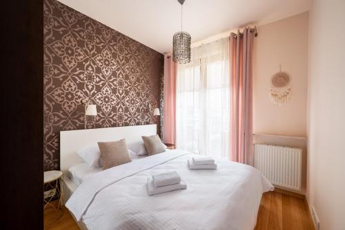- une chambre avec 2 lits blancs et une fenêtre dans l'établissement Obrzeżna Beige Apartment, à Varsovie