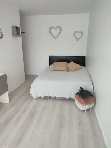 une chambre blanche avec un lit et un parquet dans l'établissement studio avec piscine, à Gruissan