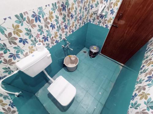 W niebieskim pokoju znajduje się łazienka z białą toaletą. w obiekcie Skylight Residency Yercaud w mieście Yercaud