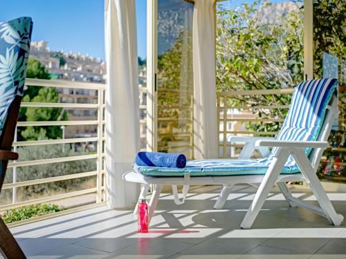 a rocking chair on a porch with a view of the city at Apartment Zeus-4 by Interhome in Calpe