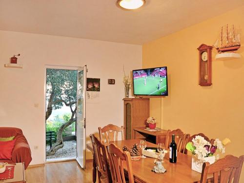 a dining room with a table and a television on the wall at Holiday Home Mario-1 by Interhome in Makarska