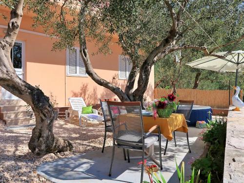 a patio with a table and chairs under a tree at Holiday Home Mario-1 by Interhome in Makarska