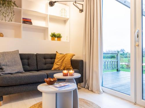 un soggiorno con divano e balcone di Holiday Home Natuurlijk de Veenhoop by Interhome a De Veenhoop