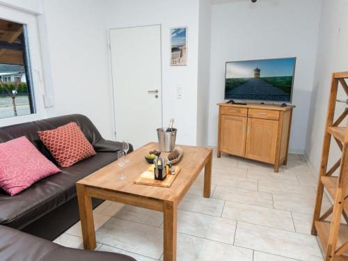 een woonkamer met een bank en een salontafel bij Apartment Backbord by Interhome in Norddeich