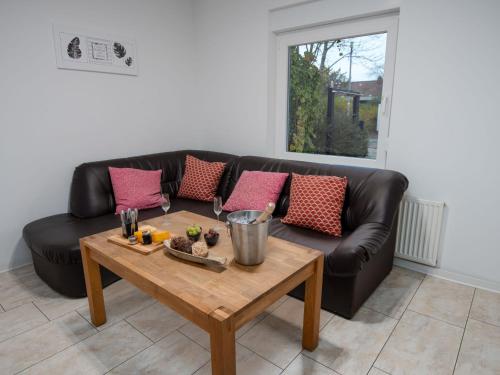 a living room with a black couch and a wooden table at Apartment Backbord by Interhome in Norddeich