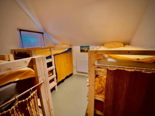 Cette petite chambre comprend 3 lits superposés. dans l'établissement Camp Hillcrest Bunkhouse, 