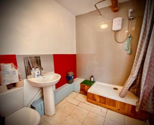 La salle de bains est pourvue d'un lavabo, de toilettes et d'une baignoire. dans l'établissement Camp Hillcrest Bunkhouse, 