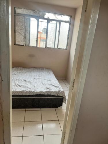 een kleine slaapkamer met een bed en een raam bij QUARTO PRIVADO PARA ALGUEL (Diária). in Goiânia
