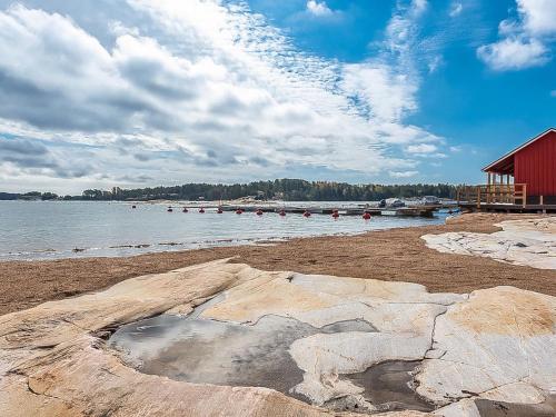 een strand met een rood gebouw en het water bij Holiday Home Kasnäs marina b 15 by Interhome in Kasnäs