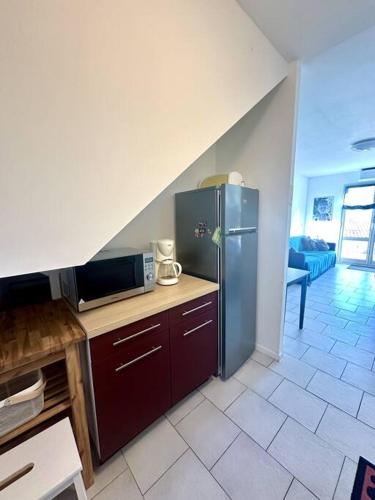 une cuisine avec un réfrigérateur en acier inoxydable dans une pièce dans l'établissement Appartement vue mer 5 personnes, à LʼÎle-Rousse