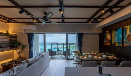 a living room with a couch and a dining room at Branchera Naha Akebono Premist R67 in Nakanishi