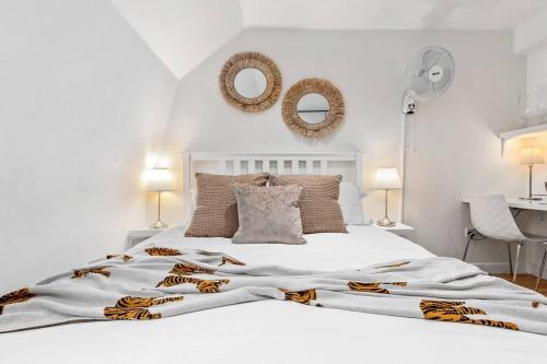 a white bed with a tiger blanket and two mirrors at Luxury 3 Bedroom Flat in Mayfair London HY4 in London