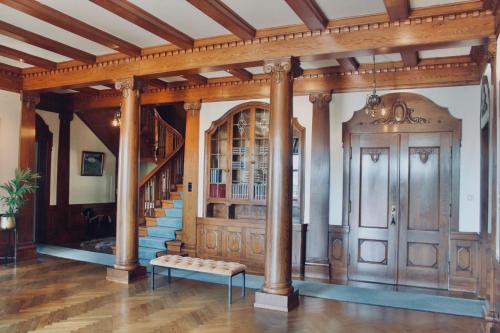uma sala de estar com colunas e uma escada numa casa em Unique Victorian Villa with private coastline em Bergen