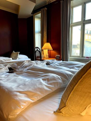two beds in a room with a window at Rye115 Hotel in Copenhagen