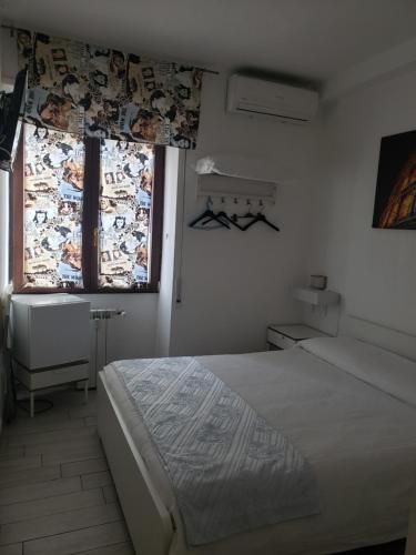 una camera bianca con un letto e una finestra di B&B metro B fronte metro a Roma