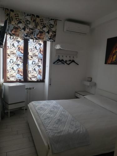 a white bedroom with a bed and a window at B&B metro B fronte metro in Rome