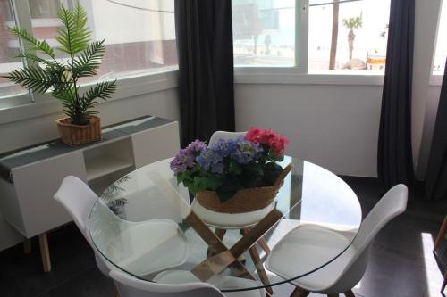 a glass table with a vase of flowers on it at Serenity by levante beach (YAGO), 7pax wi-fi A\C in Benidorm