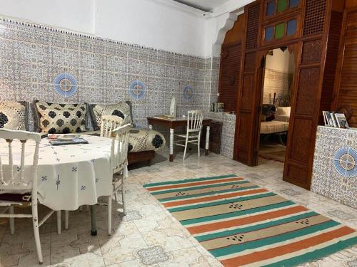 a living room with a table and chairs and a dining room at Riad Fez Hostel in Fès