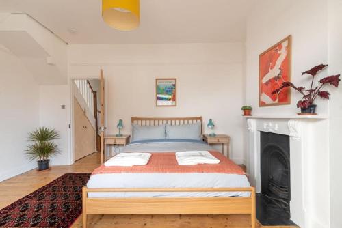 a bedroom with a bed and a fireplace at Arty House with Garden in Central Bristol in Bristol