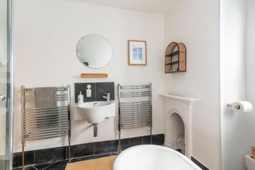 a bathroom with a sink and a mirror at Arty House with Garden in Central Bristol in Bristol