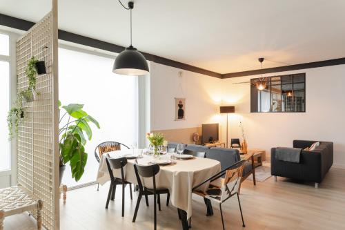 une salle à manger et un salon avec une table et des chaises dans l'établissement Le Havane - Appt de 100m2 proche centre Rennes, à Rennes