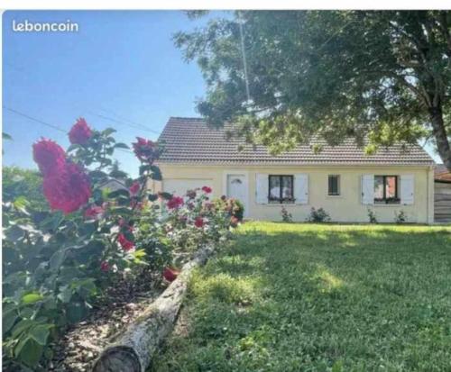 une petite maison avec une cour ornée de roses devant elle dans l'établissement charmante maison de village, 