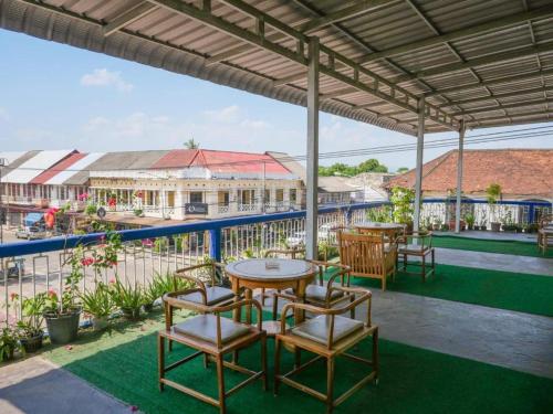 eine Terrasse mit Tischen und Stühlen und ein Gebäude in der Unterkunft KFG Guesthouse in Thakhek