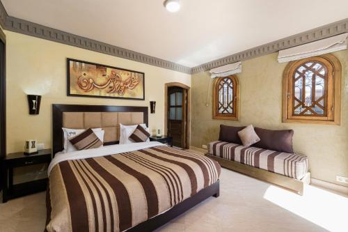 マラケシュにあるRiad Ushuaia La Villa - Centre Marrakechの広いベッドルーム(ベッド1台、ソファ付)