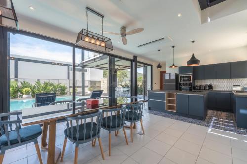 an open kitchen and dining room with a table and chairs at Totally New 4BR Private Villa Sunset Garden 2, 12m Oxygen Pool in Rawai Beach