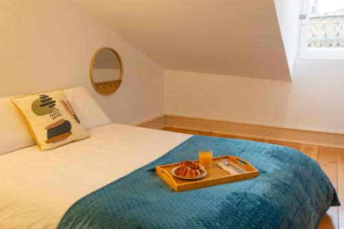 a tray of food on a bed in a room at Vinum Apartamentos 1890 in Coimbra
