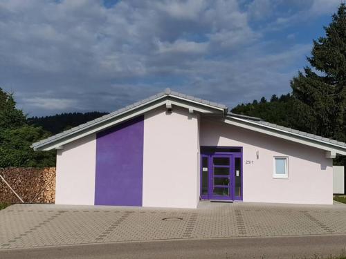 HerrischriedにあるDas Ferienhaus mit lichtem 85m² Studioの紫の扉のある白紫の建物