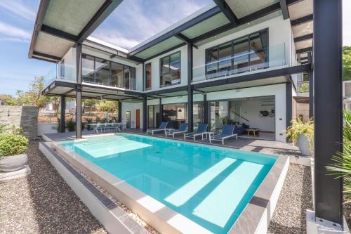 an exterior view of a house with a swimming pool at Totally New 4BR Private Villa Sunset Garden 2, 12m Oxygen Pool in Rawai Beach