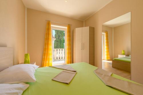 a bedroom with a green bed and a window at Apartment Puko in Bol