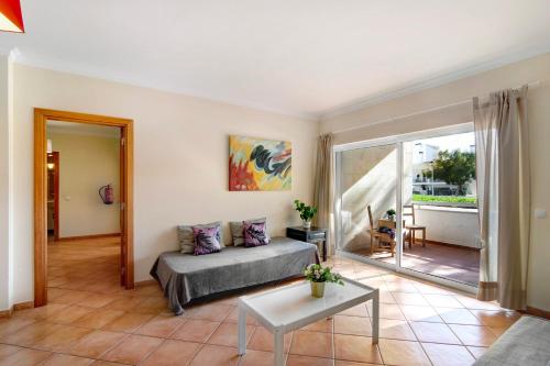 a living room with a bed and a table at Apartamento T3 Santa Luzia - H in Santa Luzia