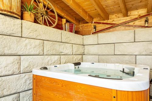 jacuzzi en una habitación con pared de piedra en Ameisberger - Landhaus, en Mollmannsreith