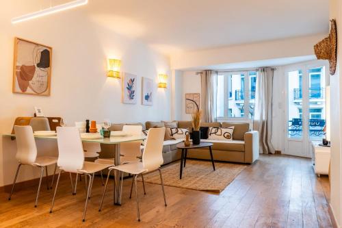 a living room with a table and chairs and a couch at SERRENDY Apartment with terrace & sea view in Cannes